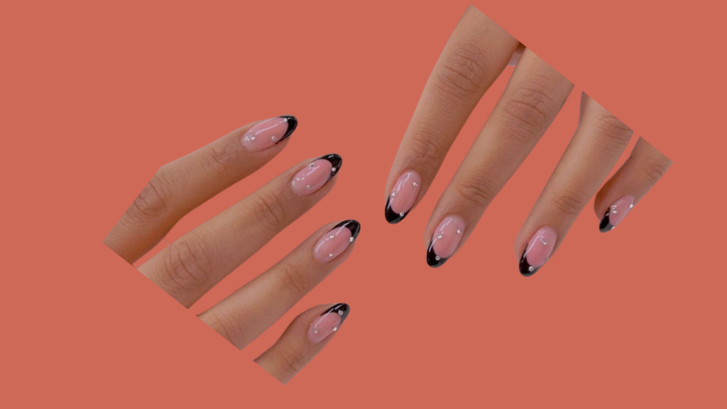 Black French tip nails with three shimmering gem accent on each nail, adding a touch of elegance and sparkle.