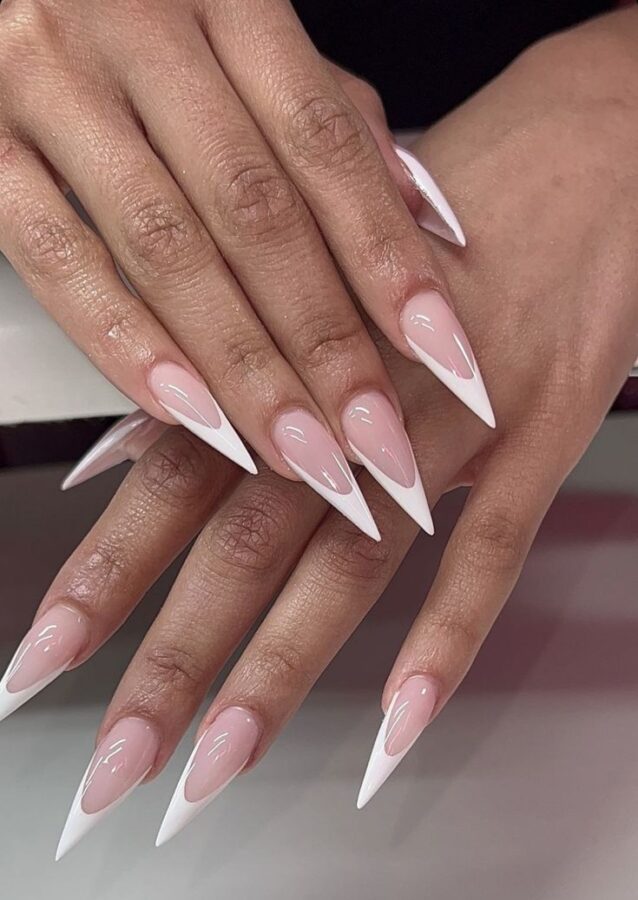 These classic white French tip stiletto nails offer a clean and sophisticated look.  A perfect manicure for any occasion. #FrenchManicure #StilettoNails #WhiteNails #ClassicNails #ElegantNails #NailArt #Manicure