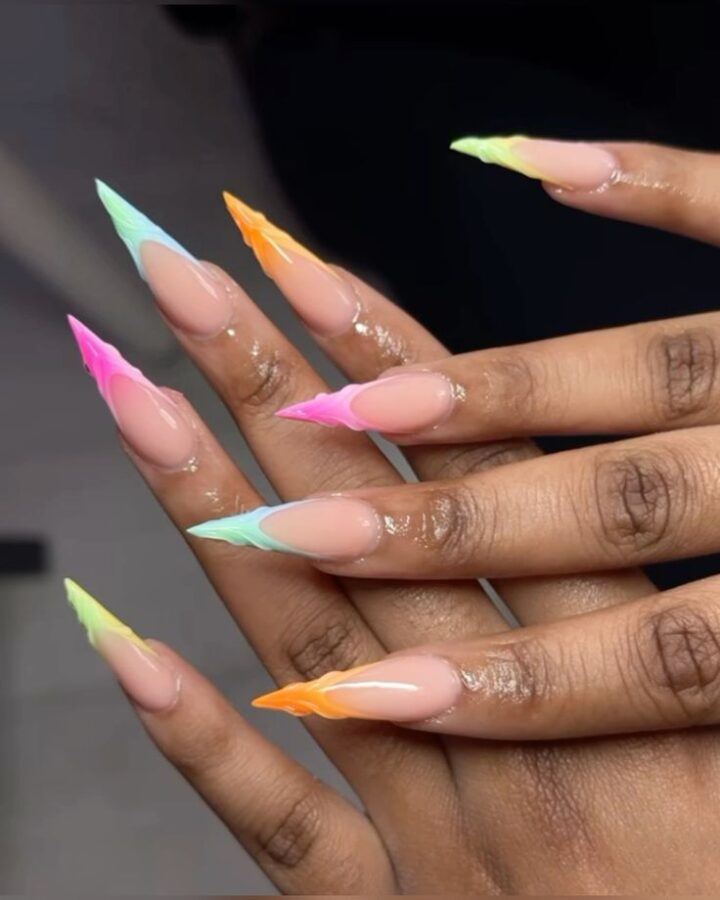 A playful burst of color: These pastel rainbow French stiletto tips bring a cheerful and trendy vibe to a classic pointed manicure. #PastelNails #RainbowNails #FrenchStilettoNails #StilettoNails #ColorfulNails #NailArt #SummerNails #TrendyNails