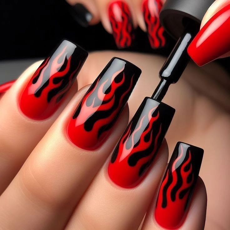 Fiery red flame nails with bold, detailed designs, creating a striking and edgy look perfect for daring baddie nail ideas.