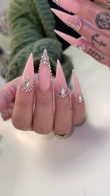 Sparkle and shine with these rhinestone-studded French stiletto nails.  A touch of glamour elevates this classic manicure. #RhinestoneNails #FrenchStilettoNails #StilettoNails #GlamNails #SparkleNails #NailArt #JewelNails