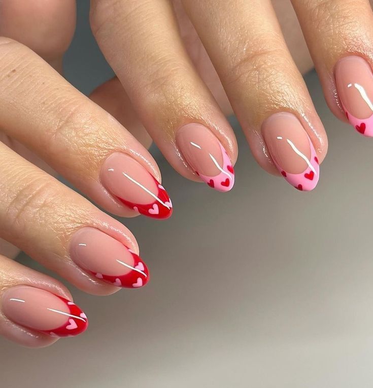 A hand displays a classic French manicure with crisp red and pinks tips on a soft pink base, a timeless and elegant choice for February nails. #FrenchManicure #ClassicNails #FebruaryNails #ElegantNails