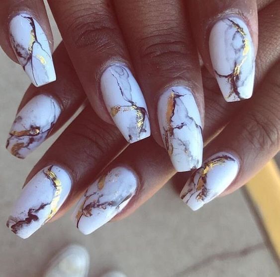 A close-up of elegant nails featuring a stunning marble on white nails design.