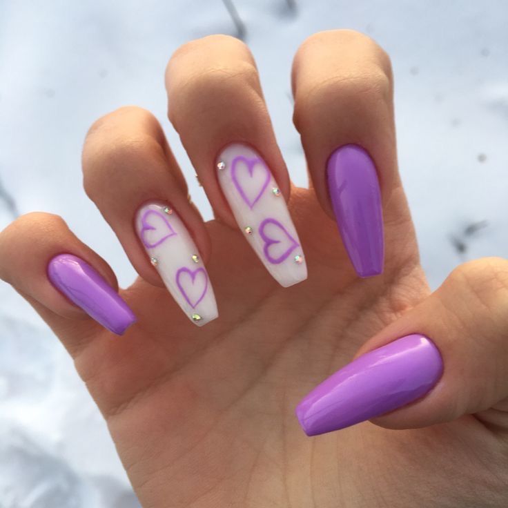 A hand displays nails painted in alternating soft pink and lavender shades, a delicate and romantic choice for February. #PastelNails #FebruaryNails #PinkAndLavender #RomanticMani