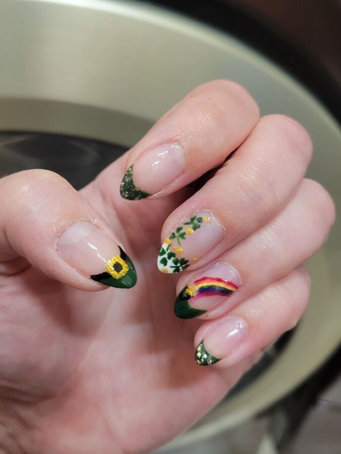 Sparkling gold accents and vibrant rainbow hues come together in these delightful St. Patrick's Day nail designs, complete with lucky pots of gold.  #StPatricksDayNails #RainbowAndGold #PotOfGoldCharm #NailArtInspiration #FestiveGlam