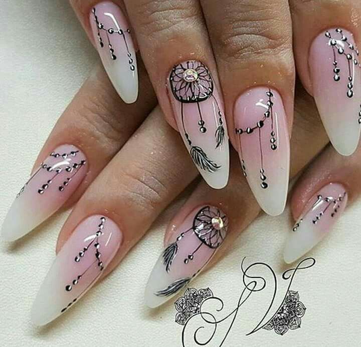 Close-up photo of manicured nails featuring dreamcatcher designs complete with delicate feathers and beads. A beautiful and intricate Western nail art idea. #westernmanicures #feathers #beads #nailartinspo